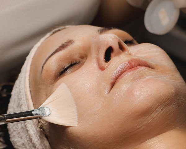 Skin rejuvenation solution applied to the face with a brush — illustrative image